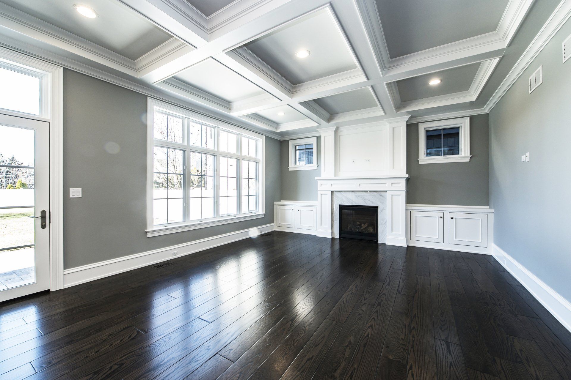 An empty living room with hardwood floors and a fireplace.