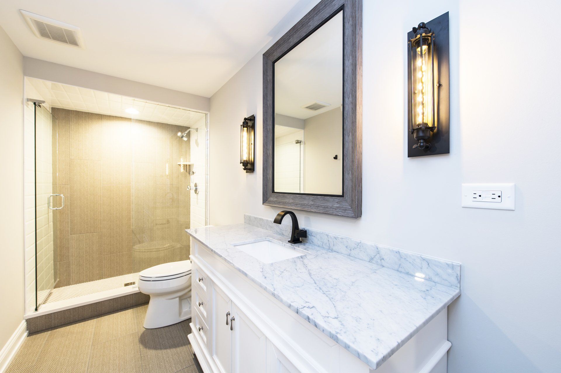 A bathroom with a toilet , sink , mirror and shower.