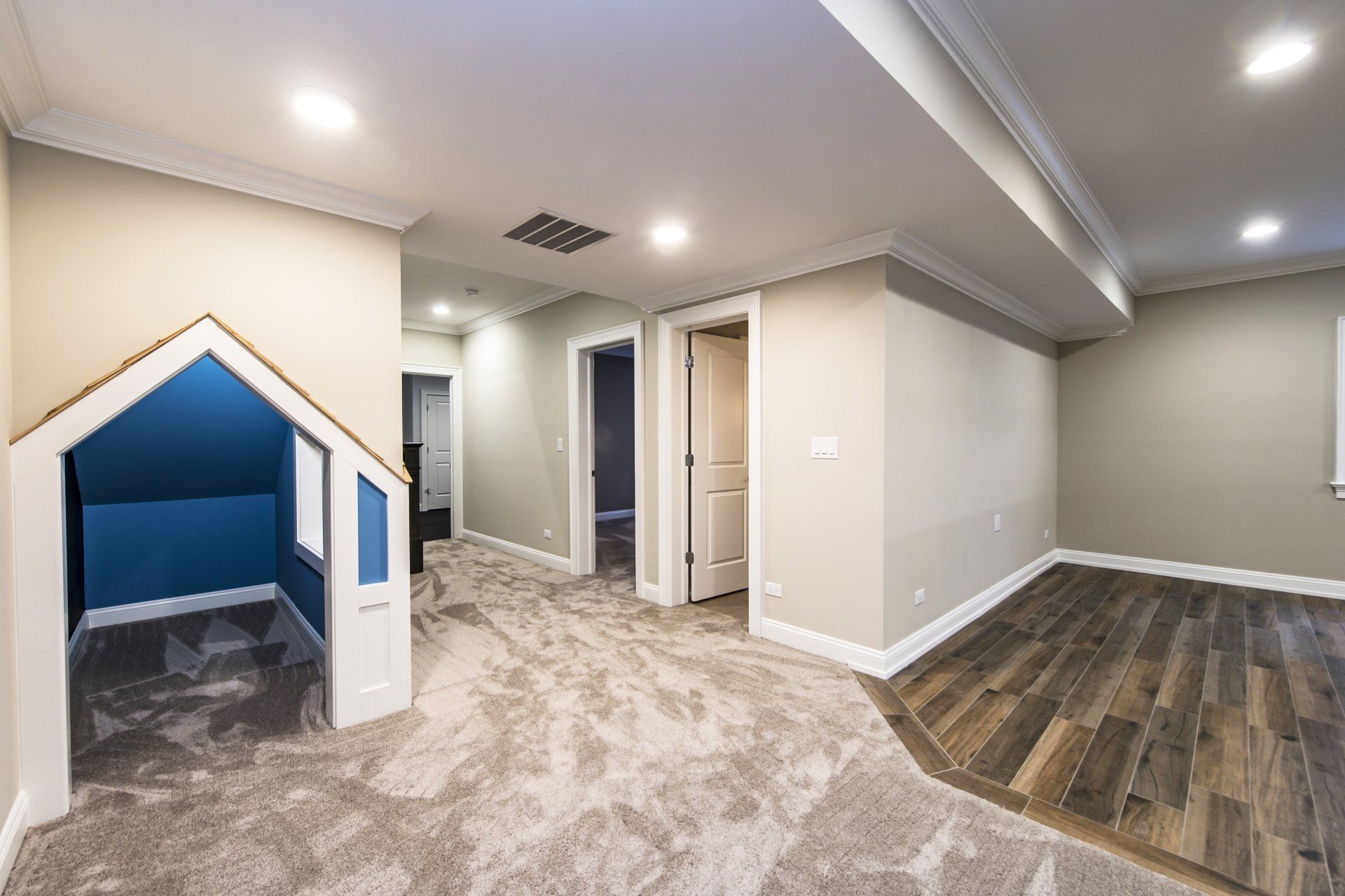 A basement with a dog house in the corner.