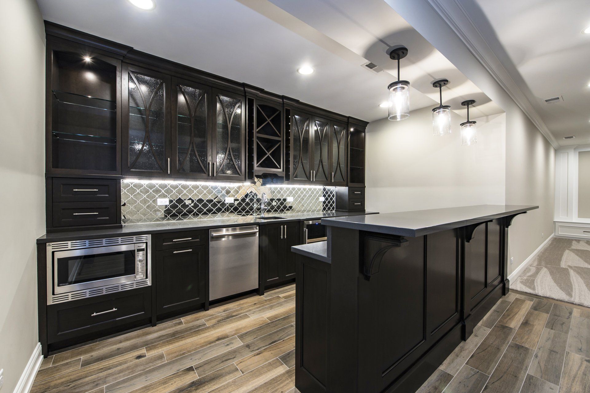 A kitchen with black cabinets and stainless steel appliances