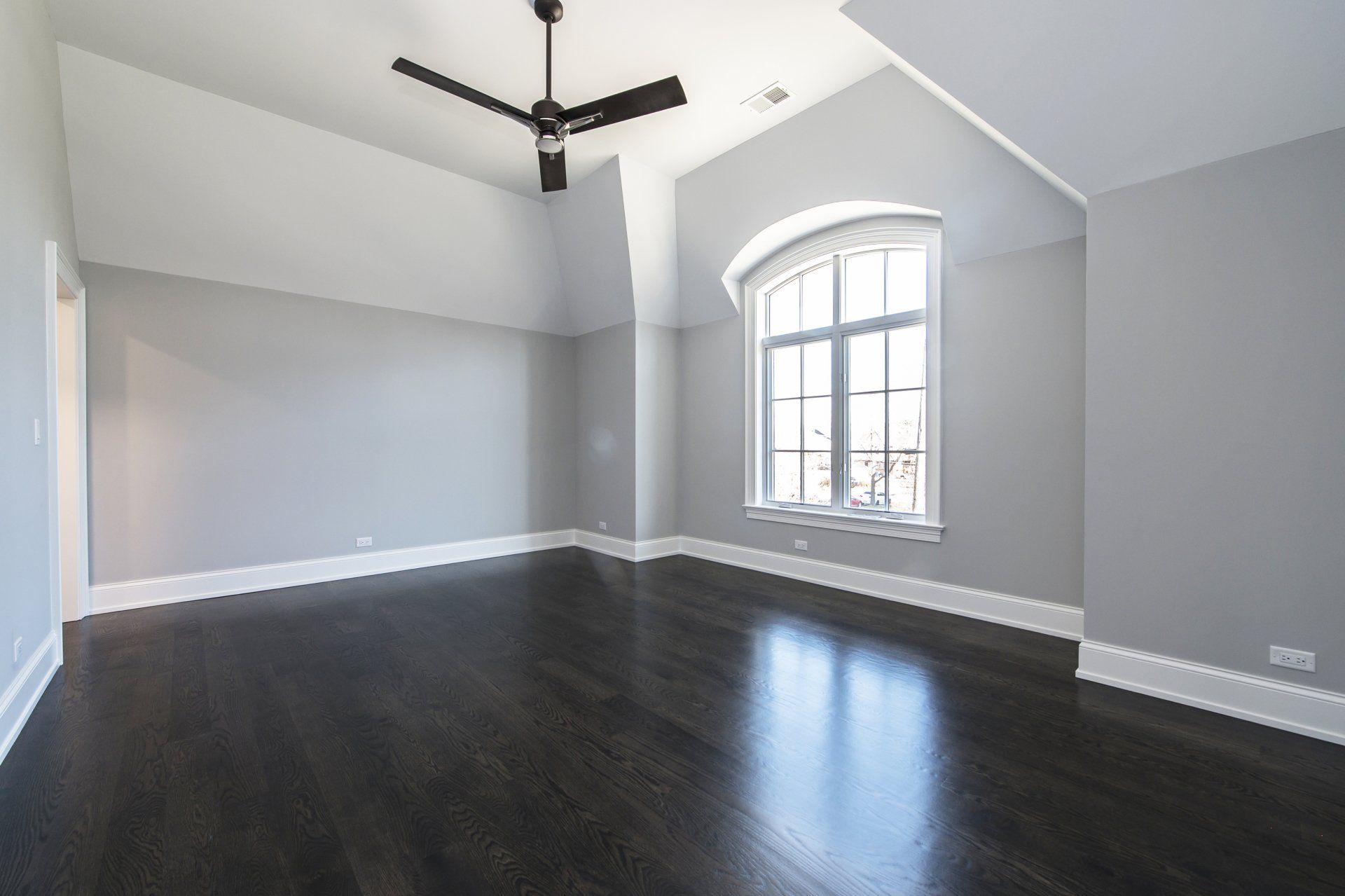 An empty room with a ceiling fan and a window
