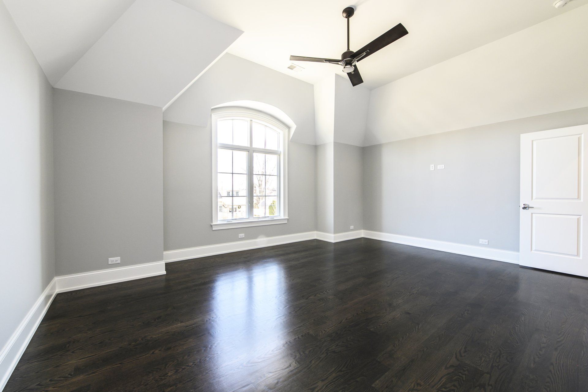 An empty room with a ceiling fan and a window