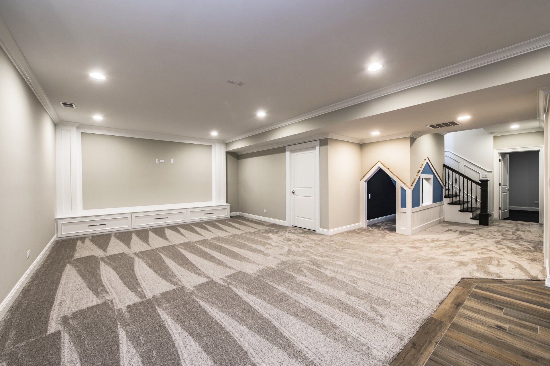 An empty basement with a staircase leading to the second floor.