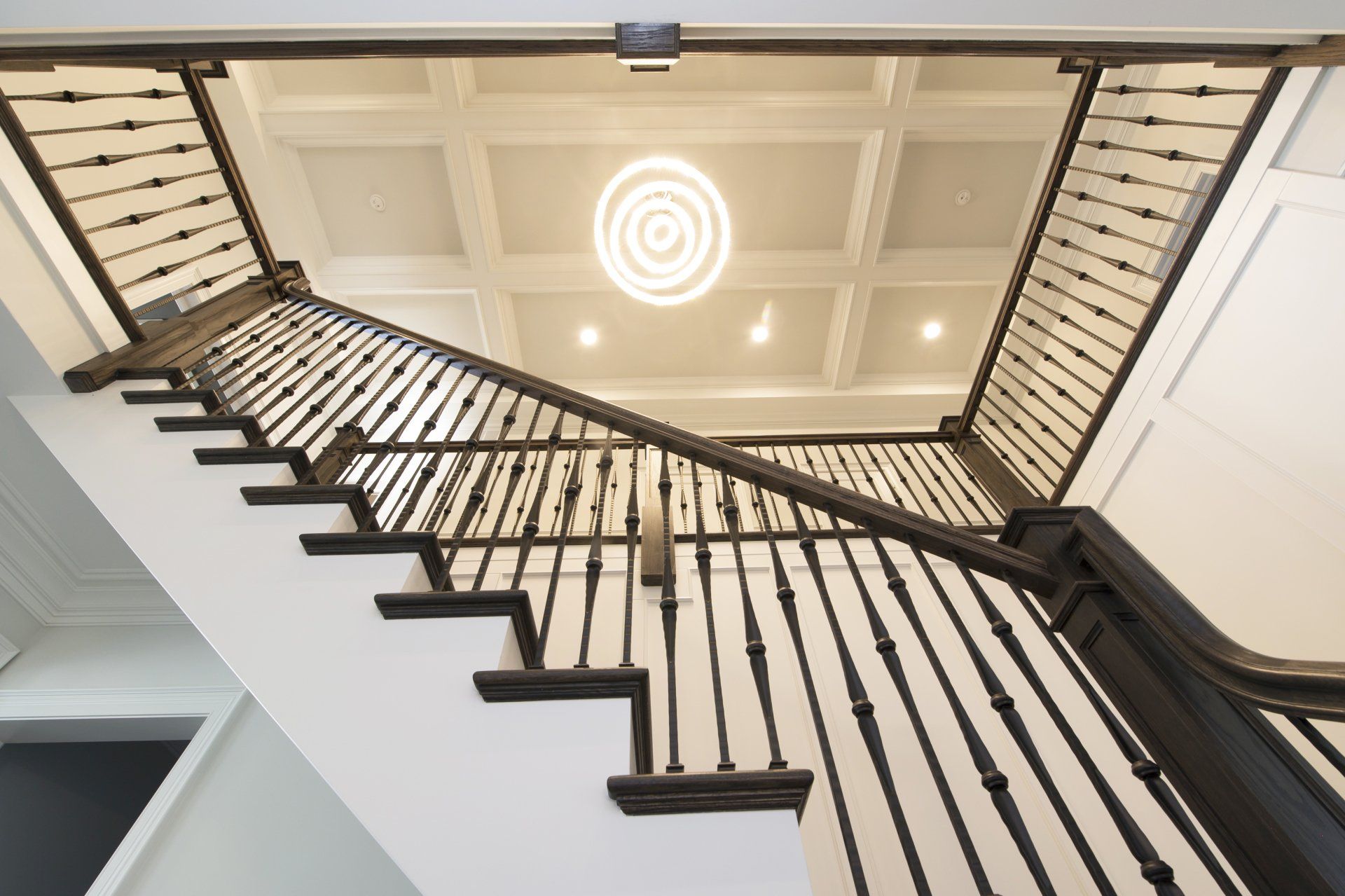 A staircase with a black railing and a light on the ceiling.