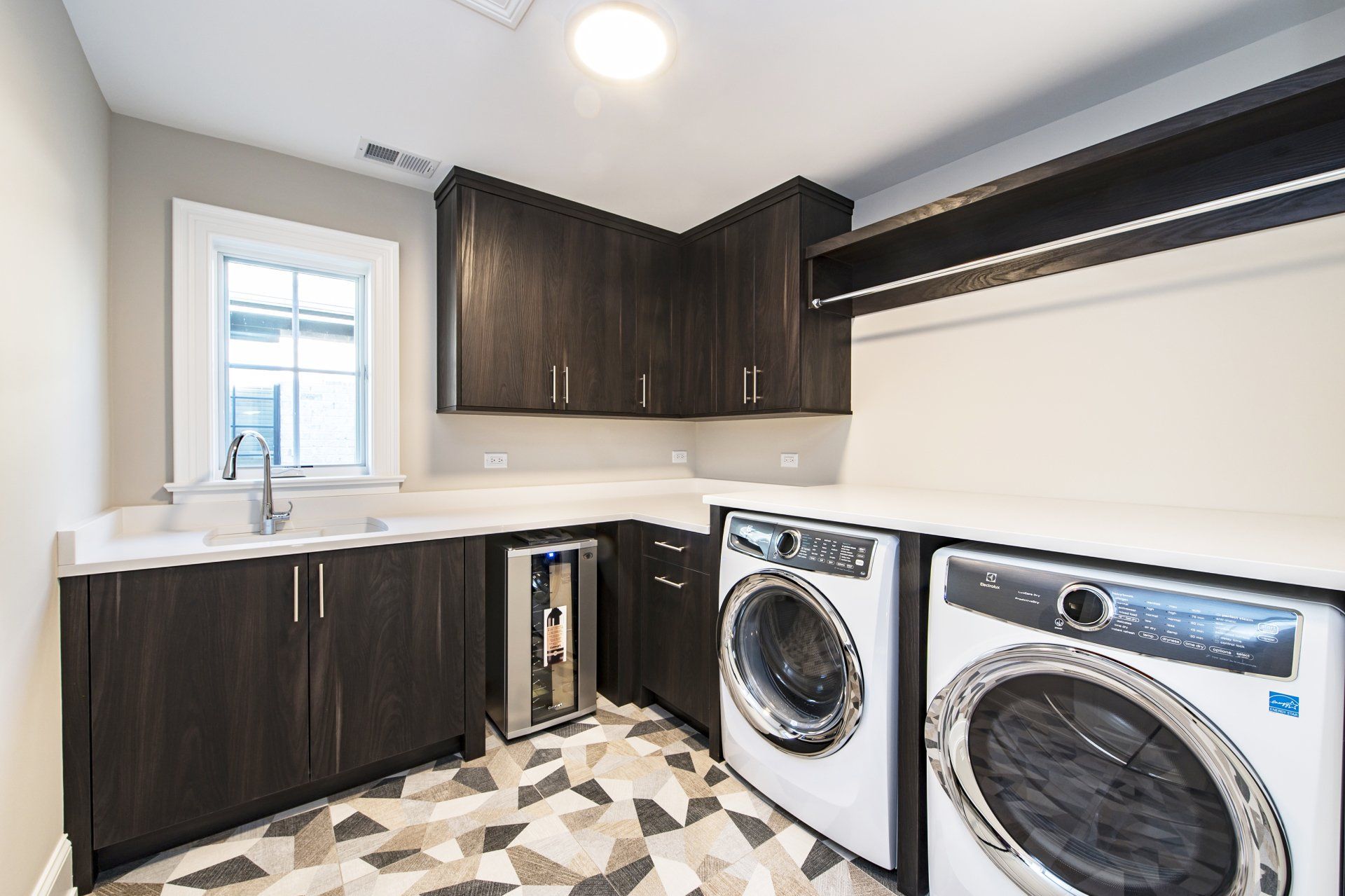 A laundry room with a washer and dryer and a sink.