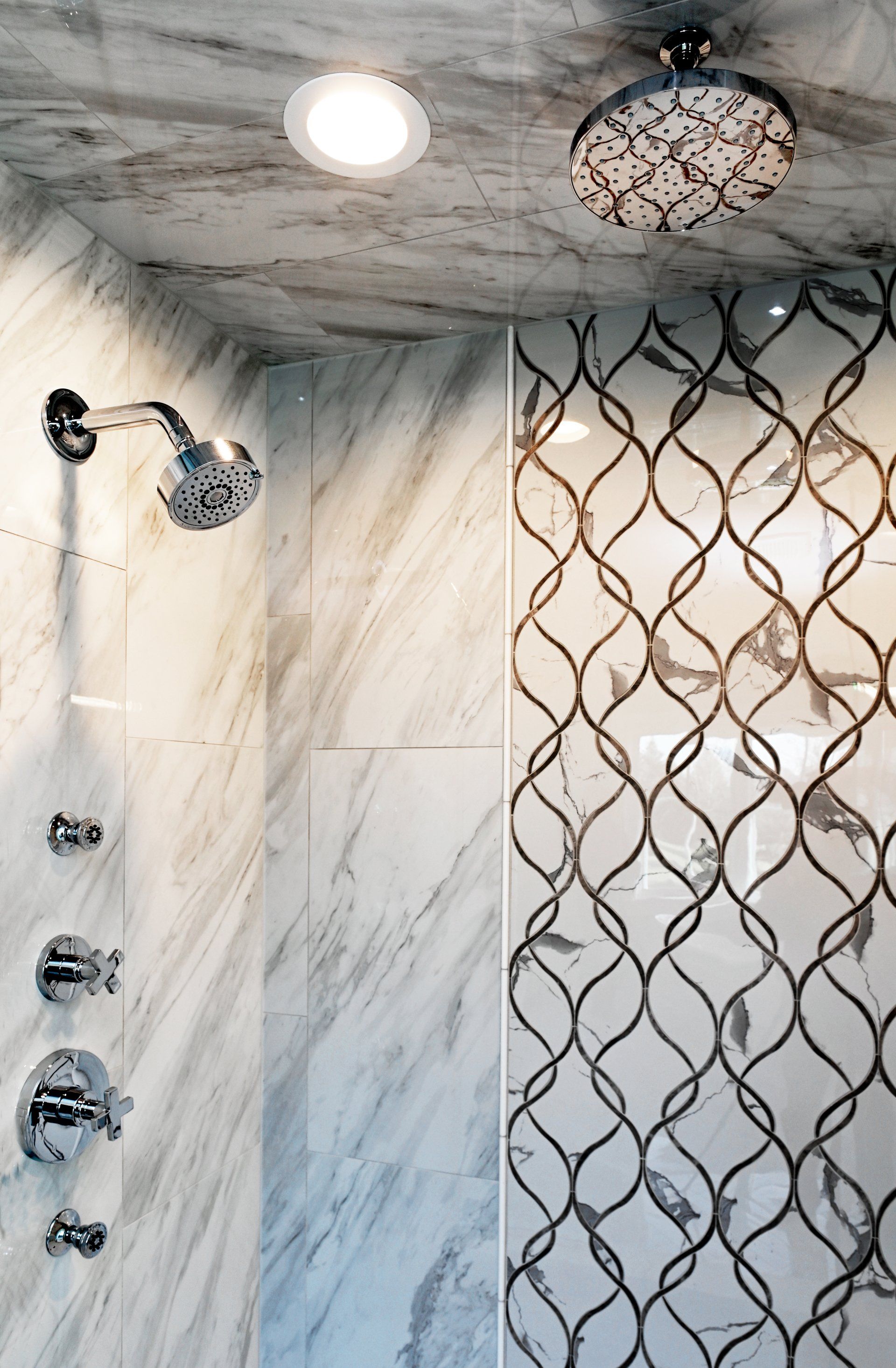 A bathroom with a shower head and a ceiling light.