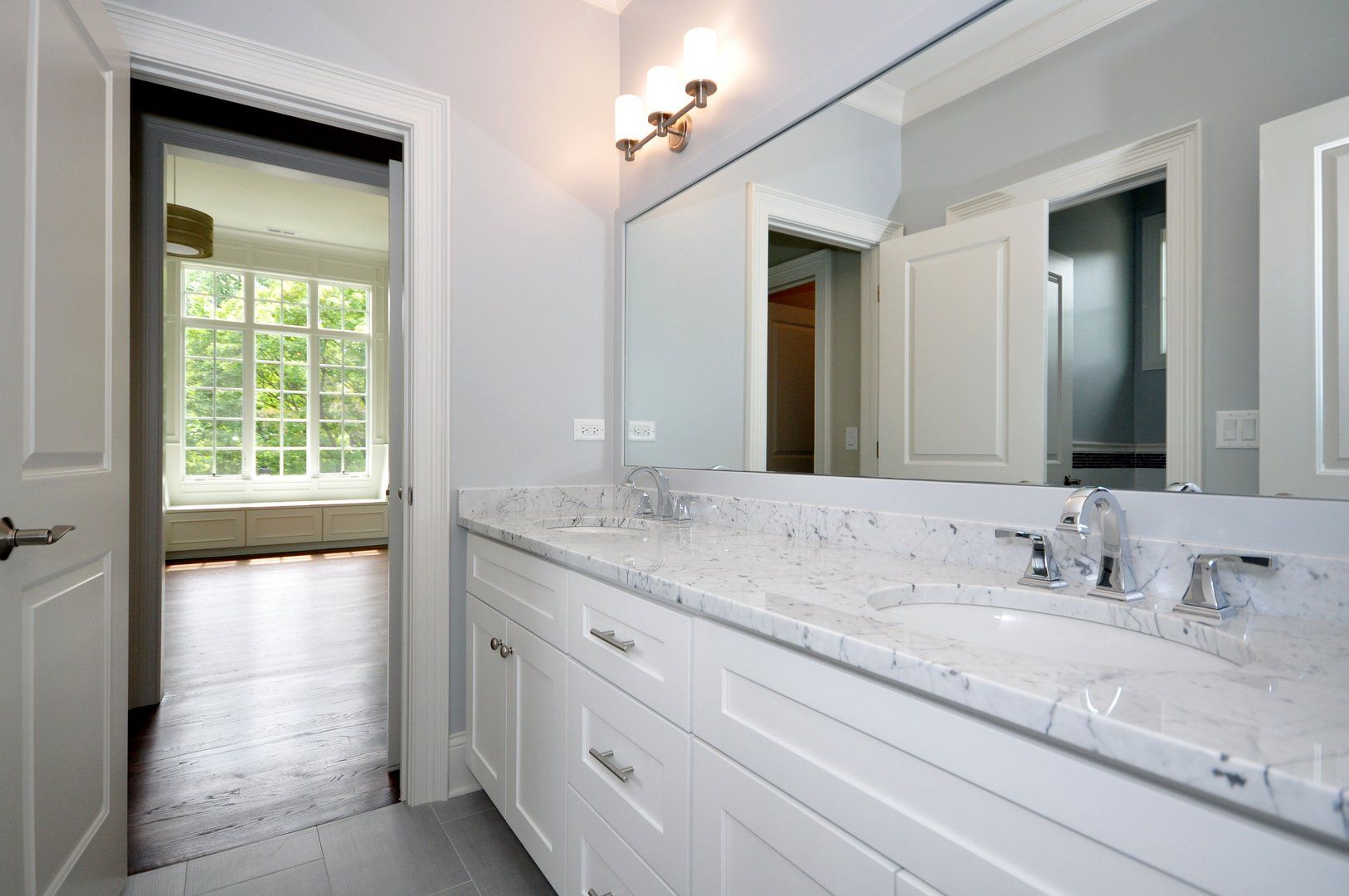 A bathroom with two sinks and a large mirror