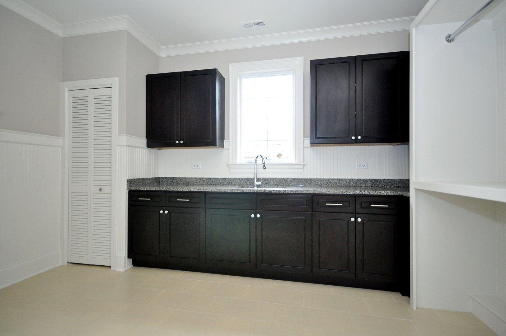 A kitchen with black cabinets and granite counter tops