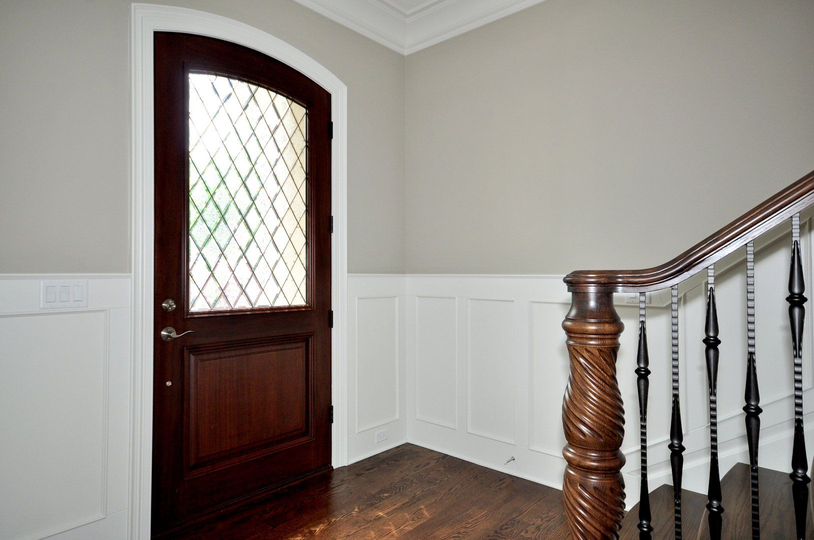 A staircase with a wooden railing and a wooden door