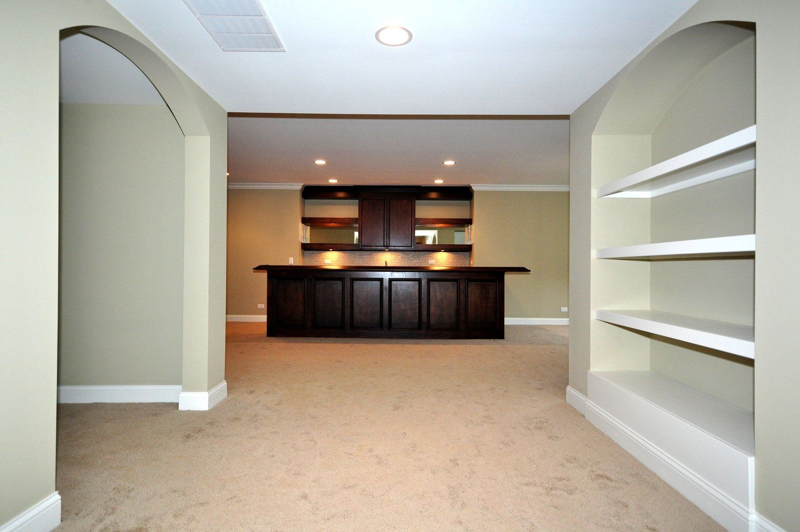 An empty basement with a bar and shelves