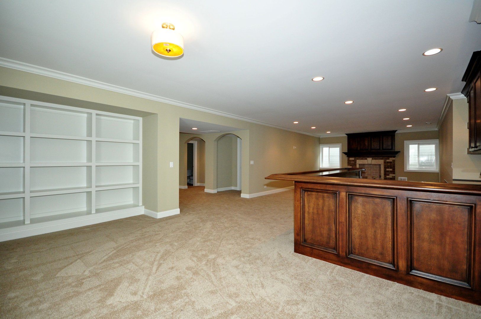 An empty basement with a wooden bar and shelves