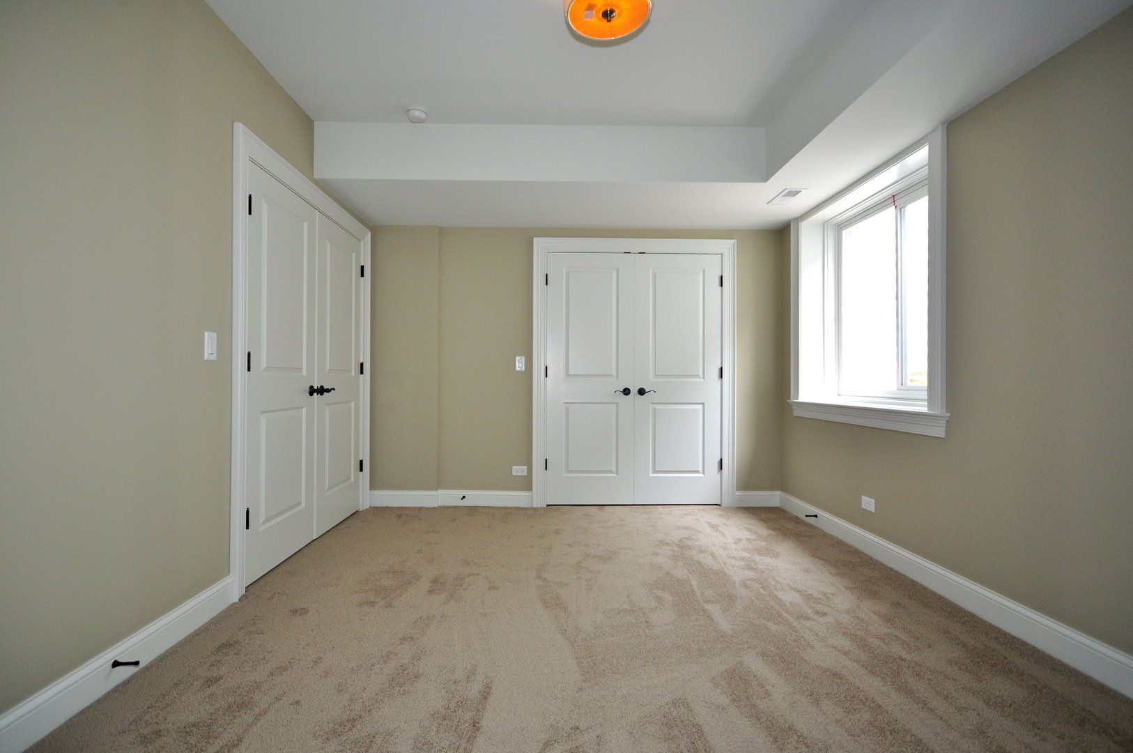 An empty room with two doors and a window