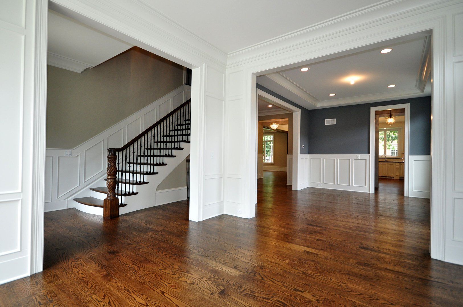 An empty house with a staircase and hardwood floors