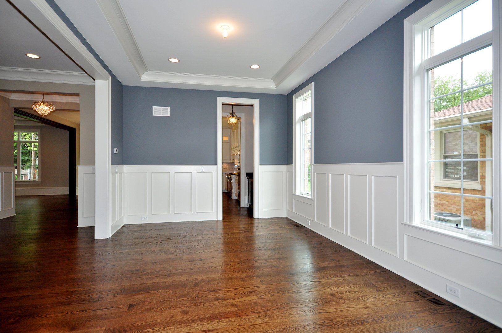 An empty living room with hardwood floors and blue walls.