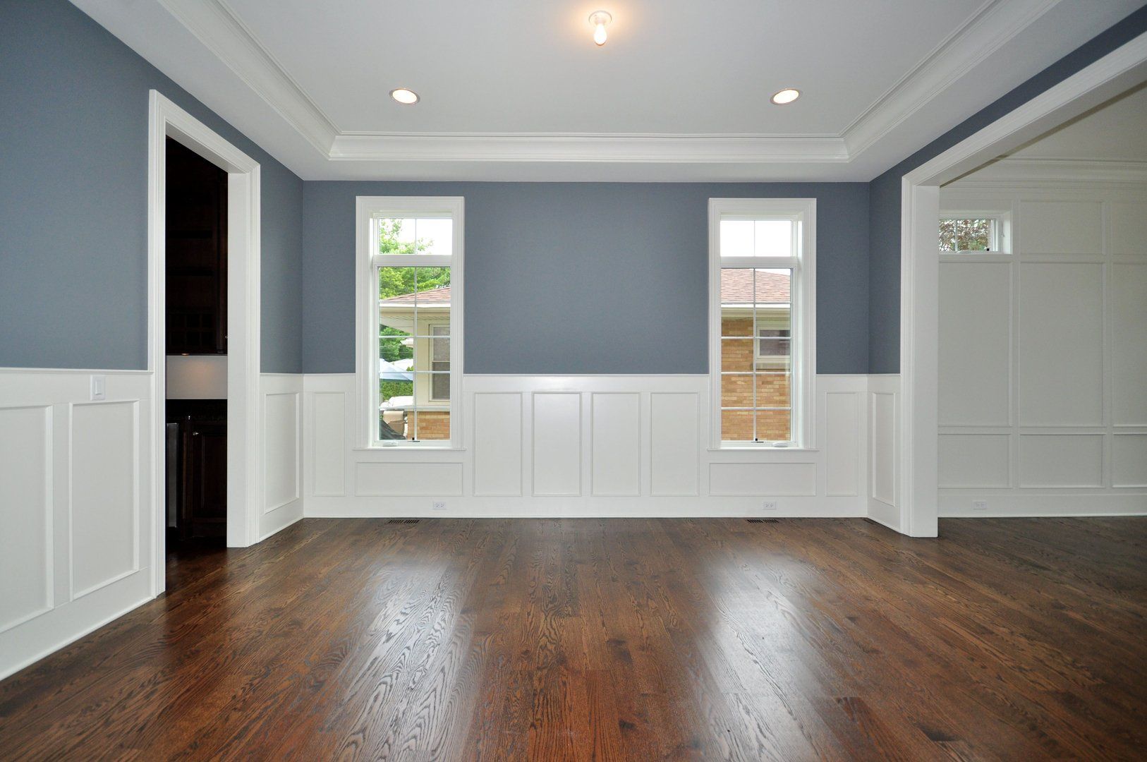 An empty room with hardwood floors and blue walls