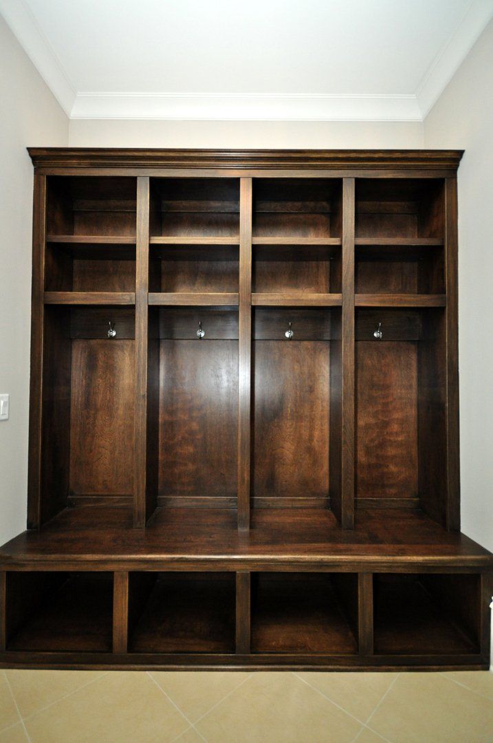 A large wooden cabinet with lots of shelves and hooks