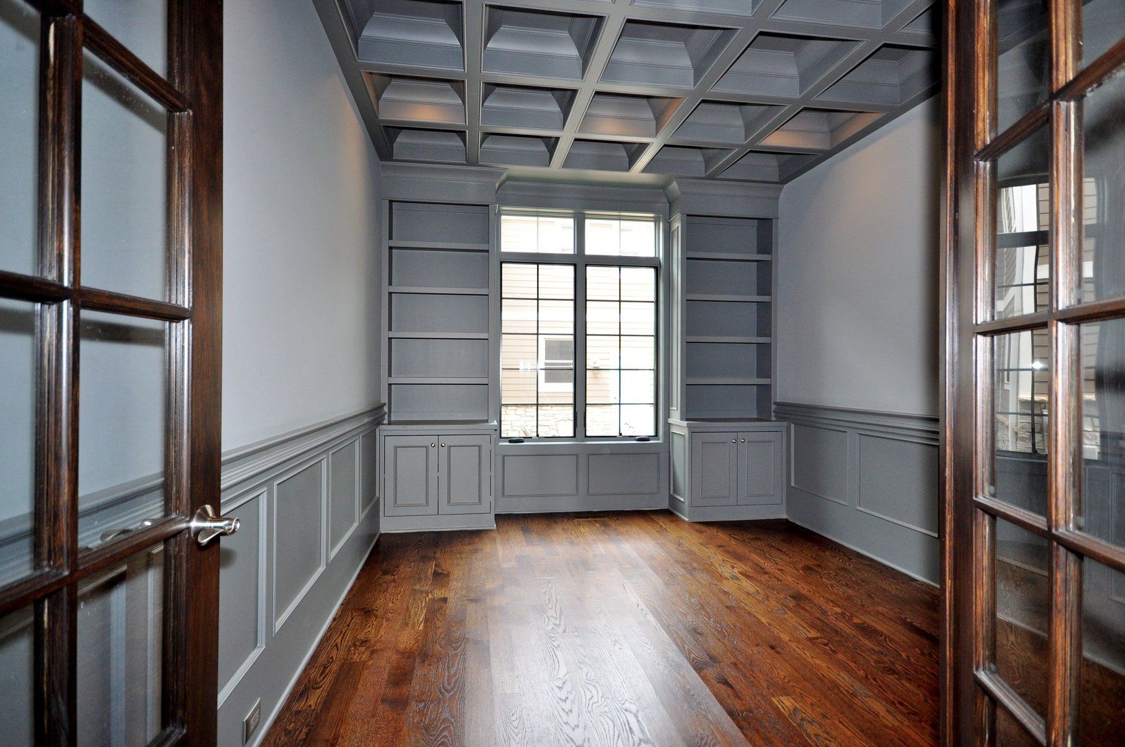 An empty room with hardwood floors and a ceiling