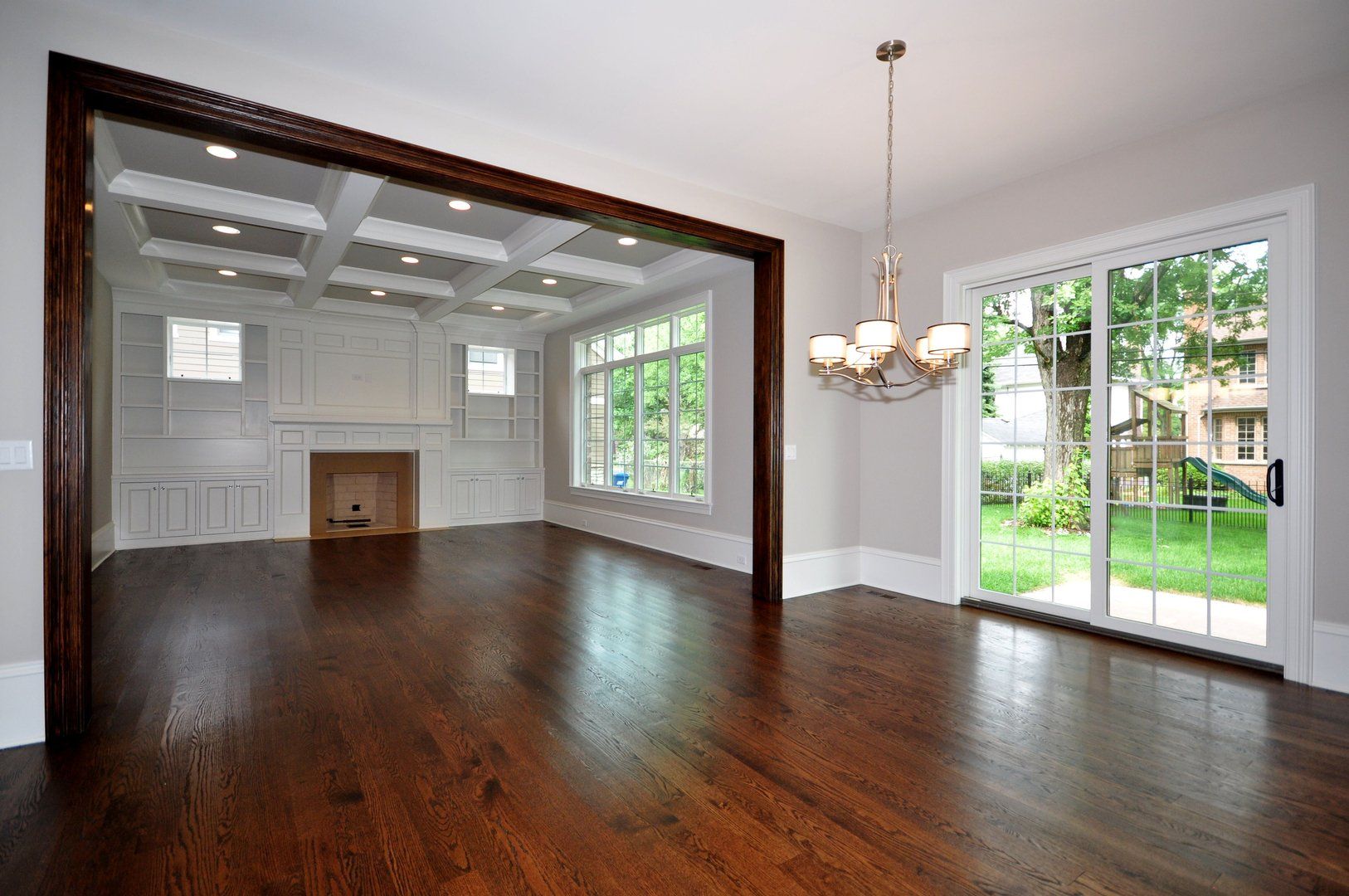 An empty living room with hardwood floors and a fireplace.