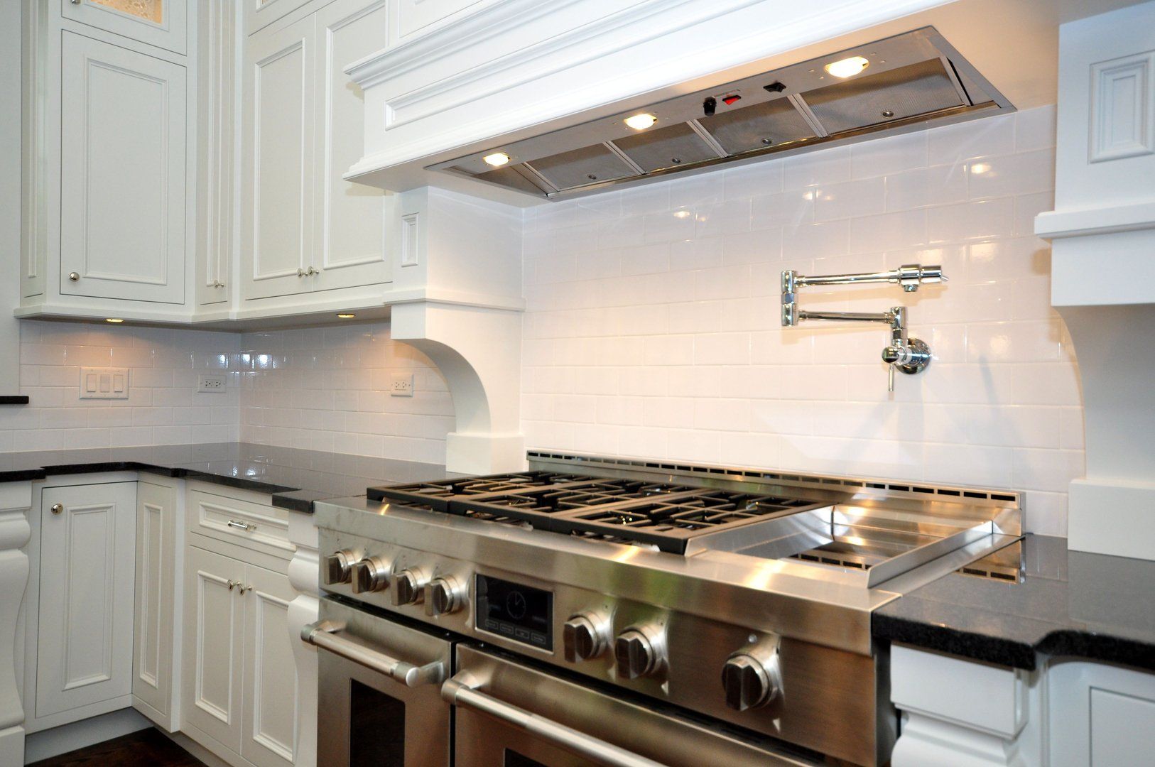 A kitchen with stainless steel appliances and white cabinets