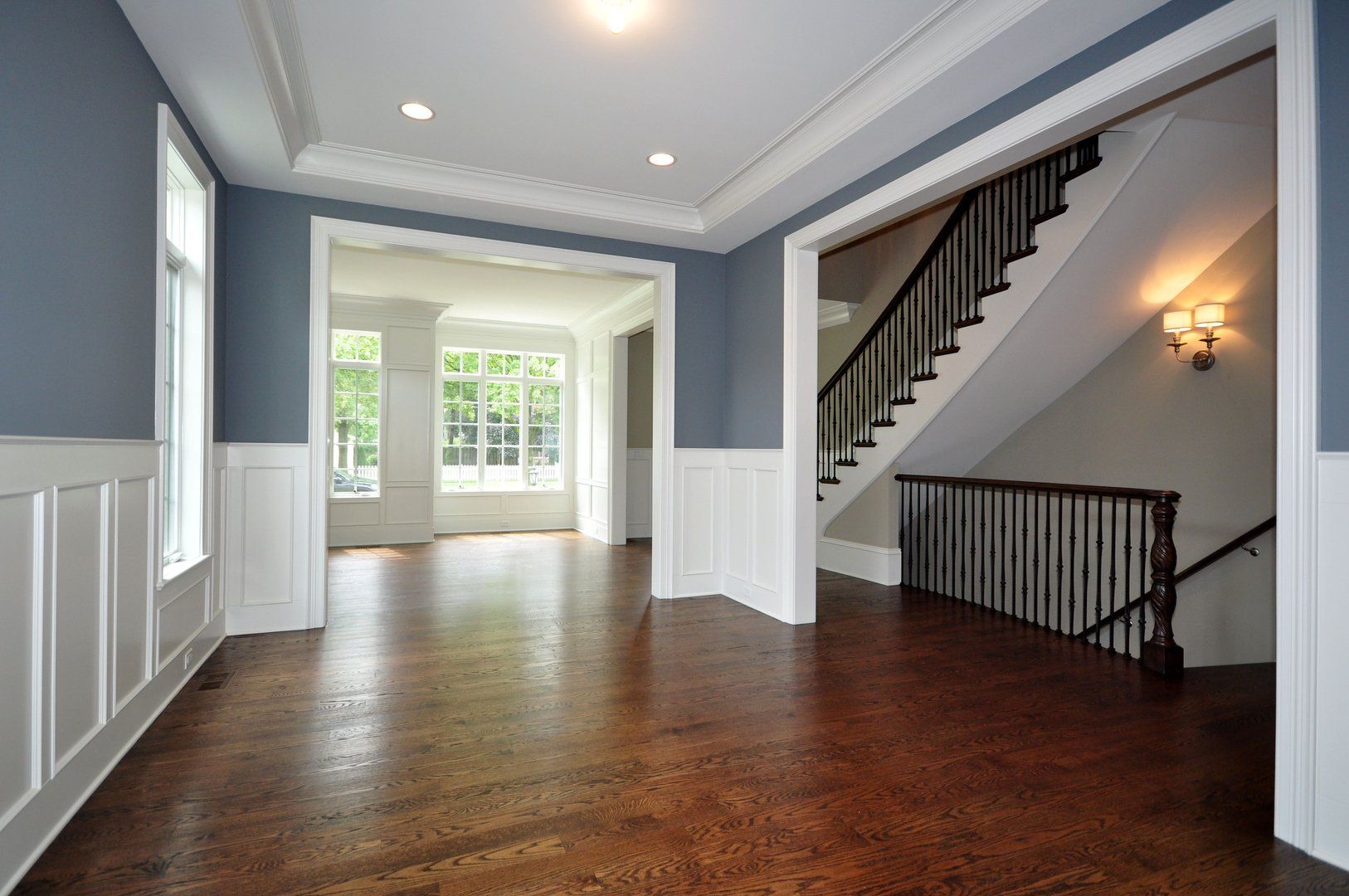 An empty hallway with hardwood floors and a staircase