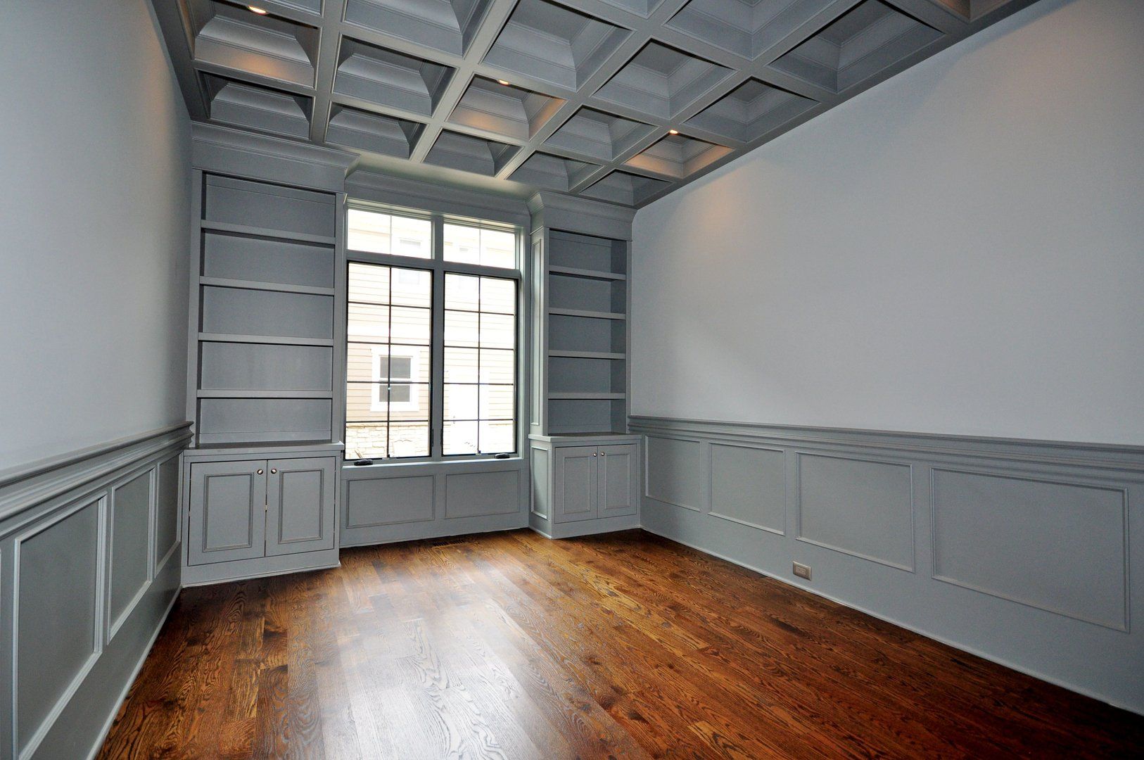 An empty room with hardwood floors and a window