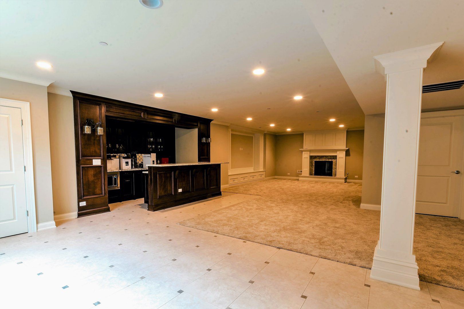 An empty basement with a bar and a fireplace.
