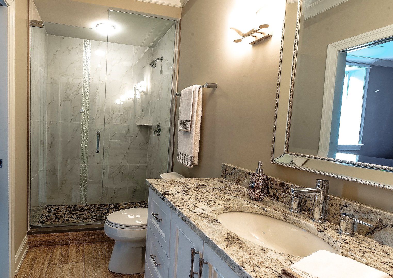 A bathroom with a toilet , sink and mirror