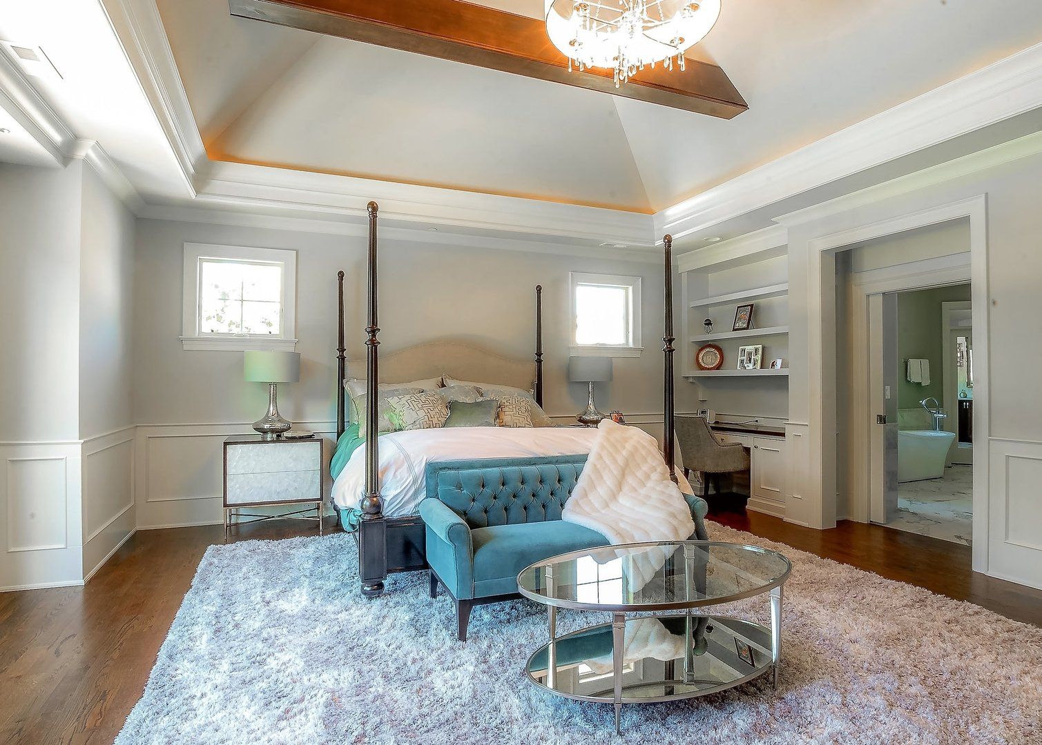 A bedroom with a bed , couch , coffee table and rug.