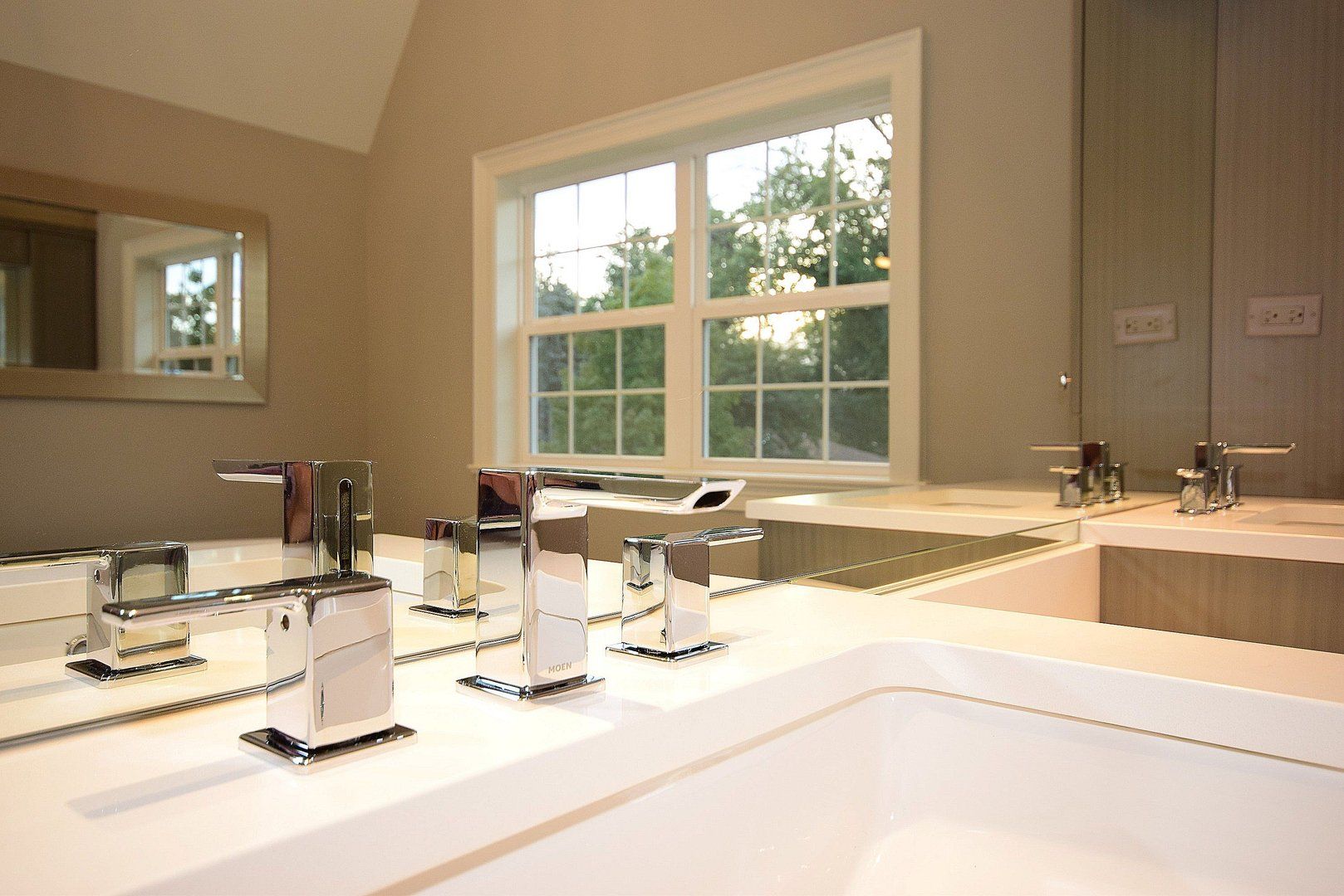 A bathroom with a sink , mirror and window