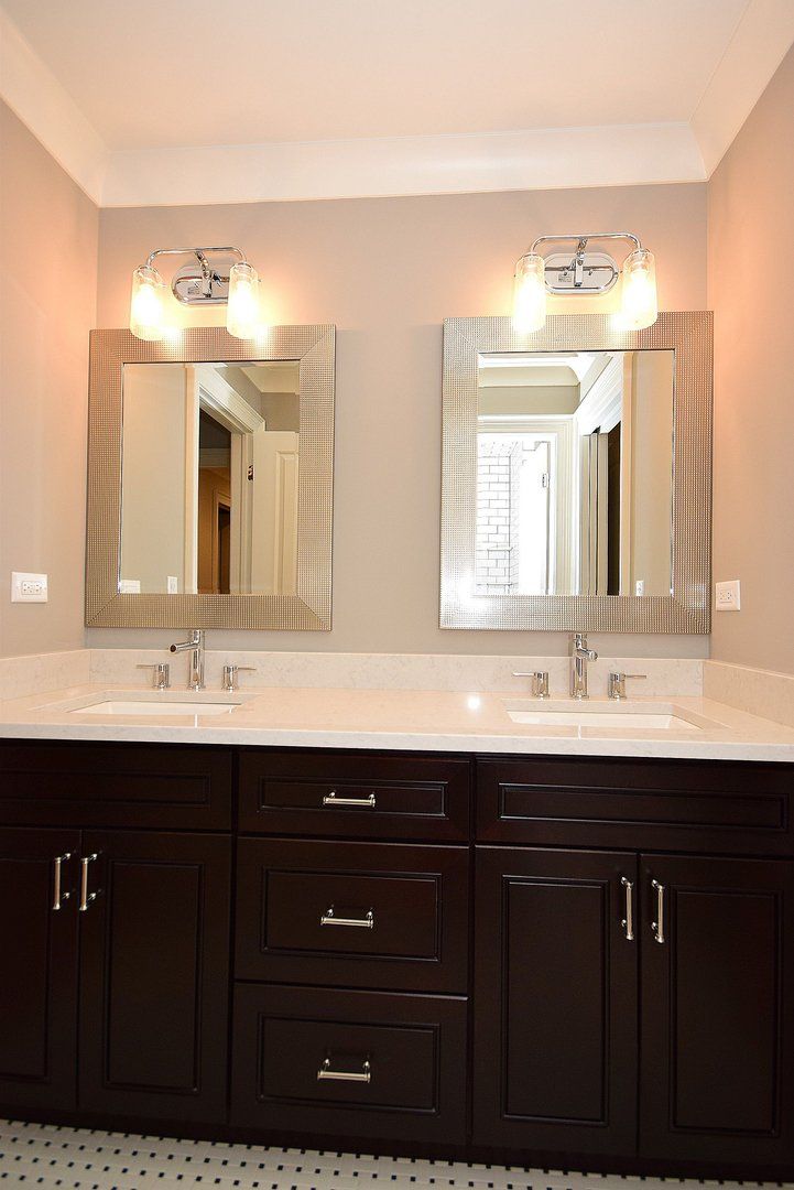 A bathroom with two sinks and two mirrors
