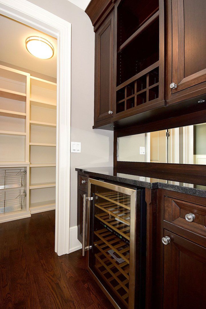 A kitchen with wooden cabinets and a wine cooler.