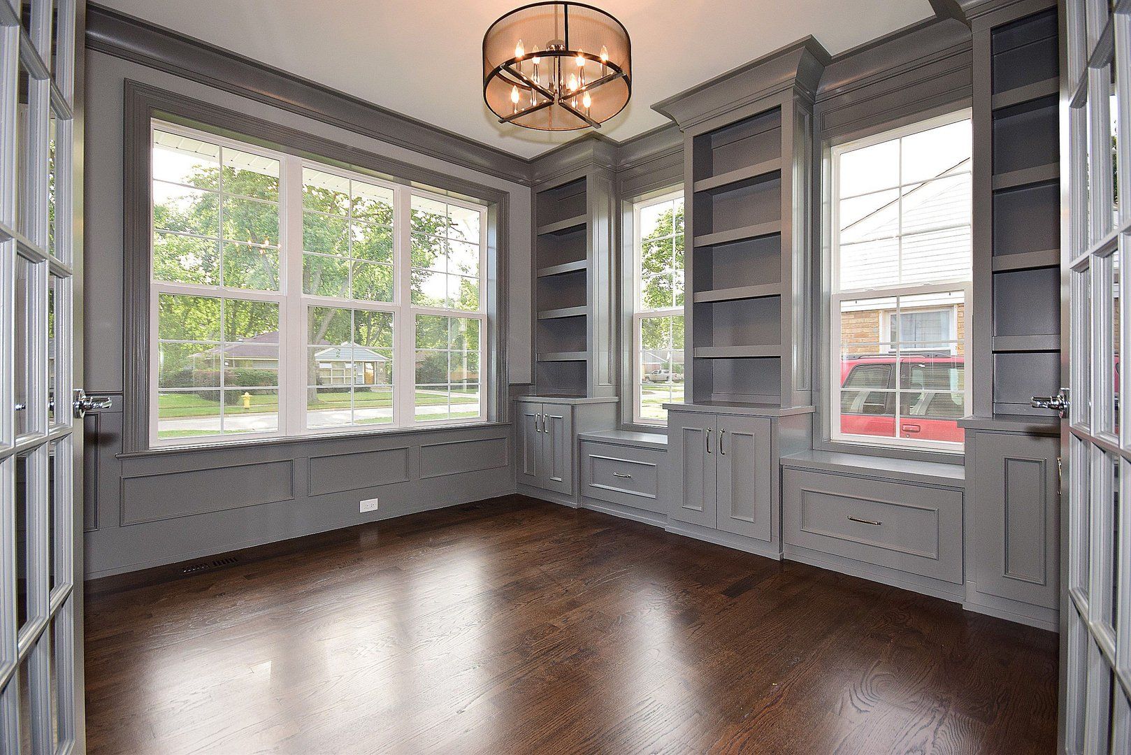 A large empty room with lots of windows and shelves.