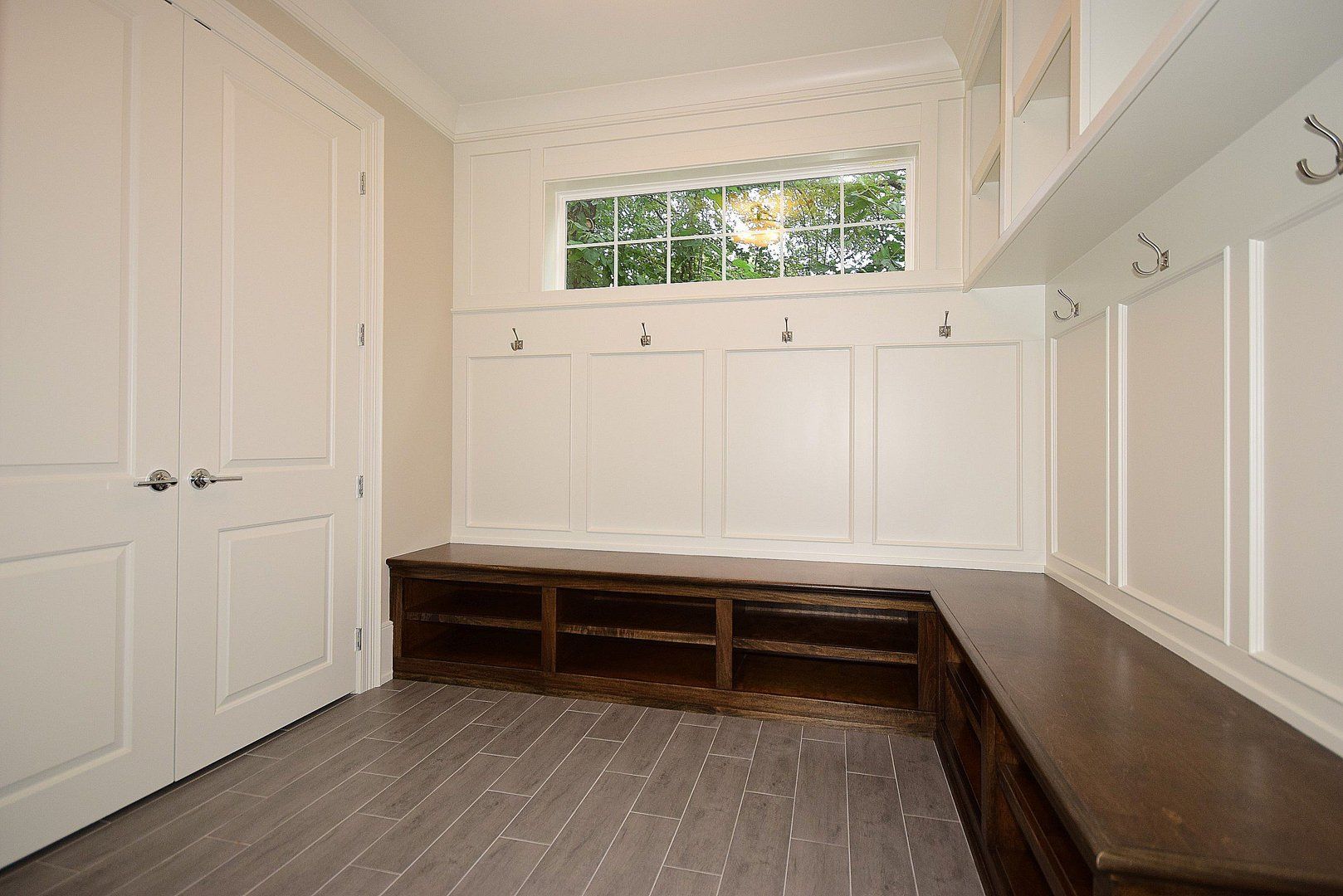A mud room with a bench and a window.