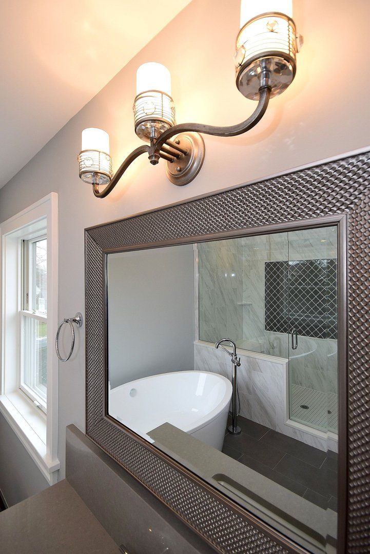 A bathroom with a large mirror and a bathtub