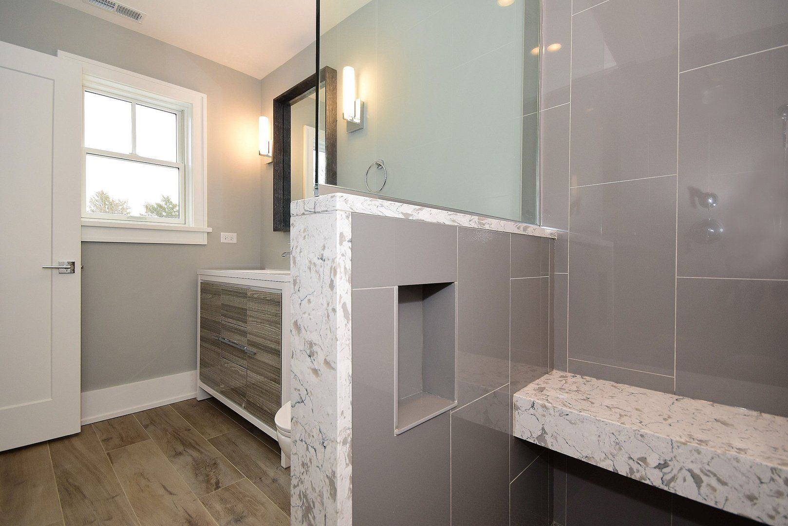 A bathroom with a sink , mirror , and bench.