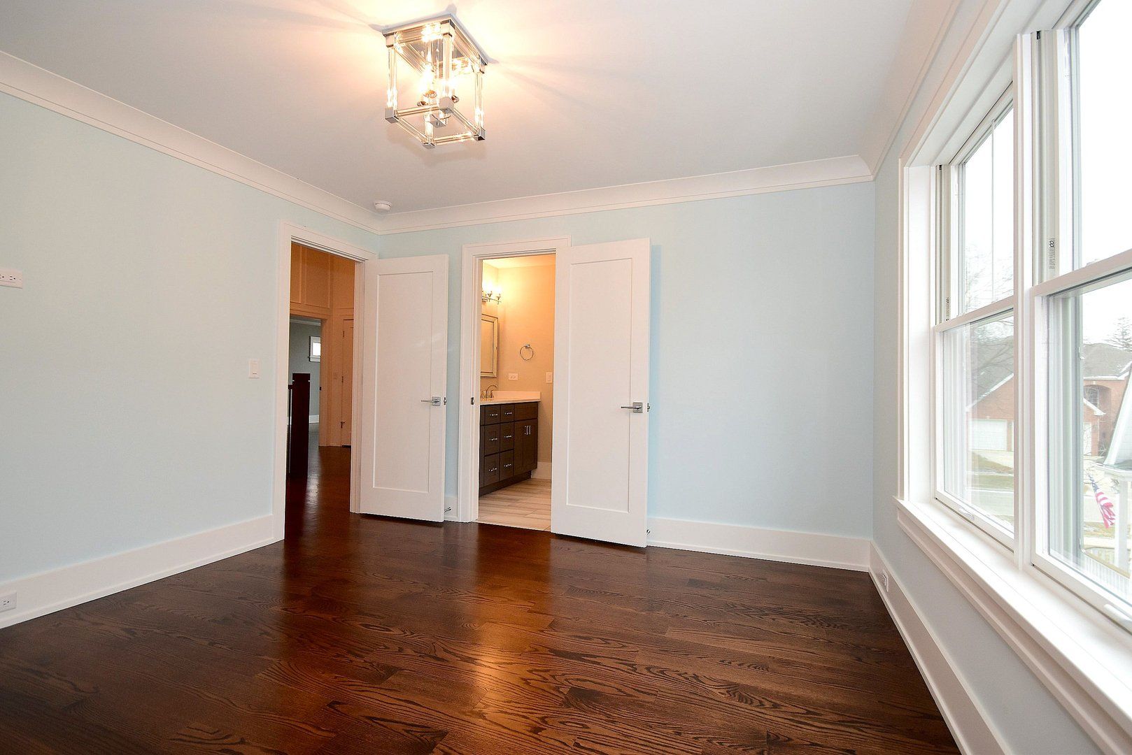 An empty room with hardwood floors and white walls.