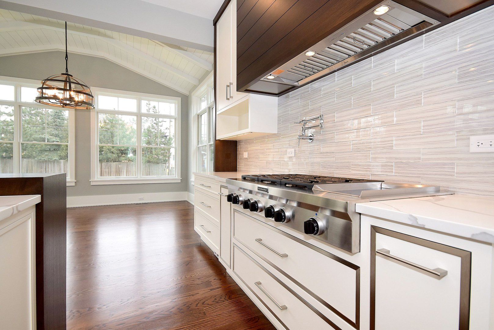 A kitchen with white cabinets and a stove top oven.
