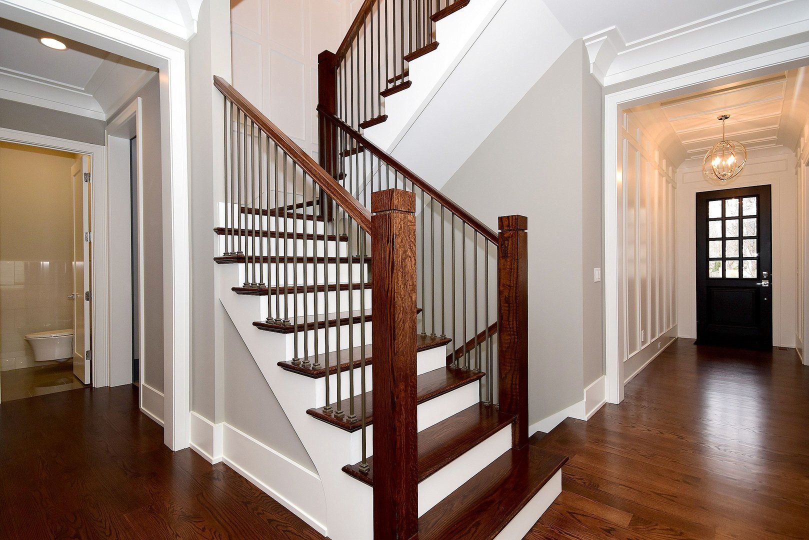 A staircase in a hallway with a wooden railing