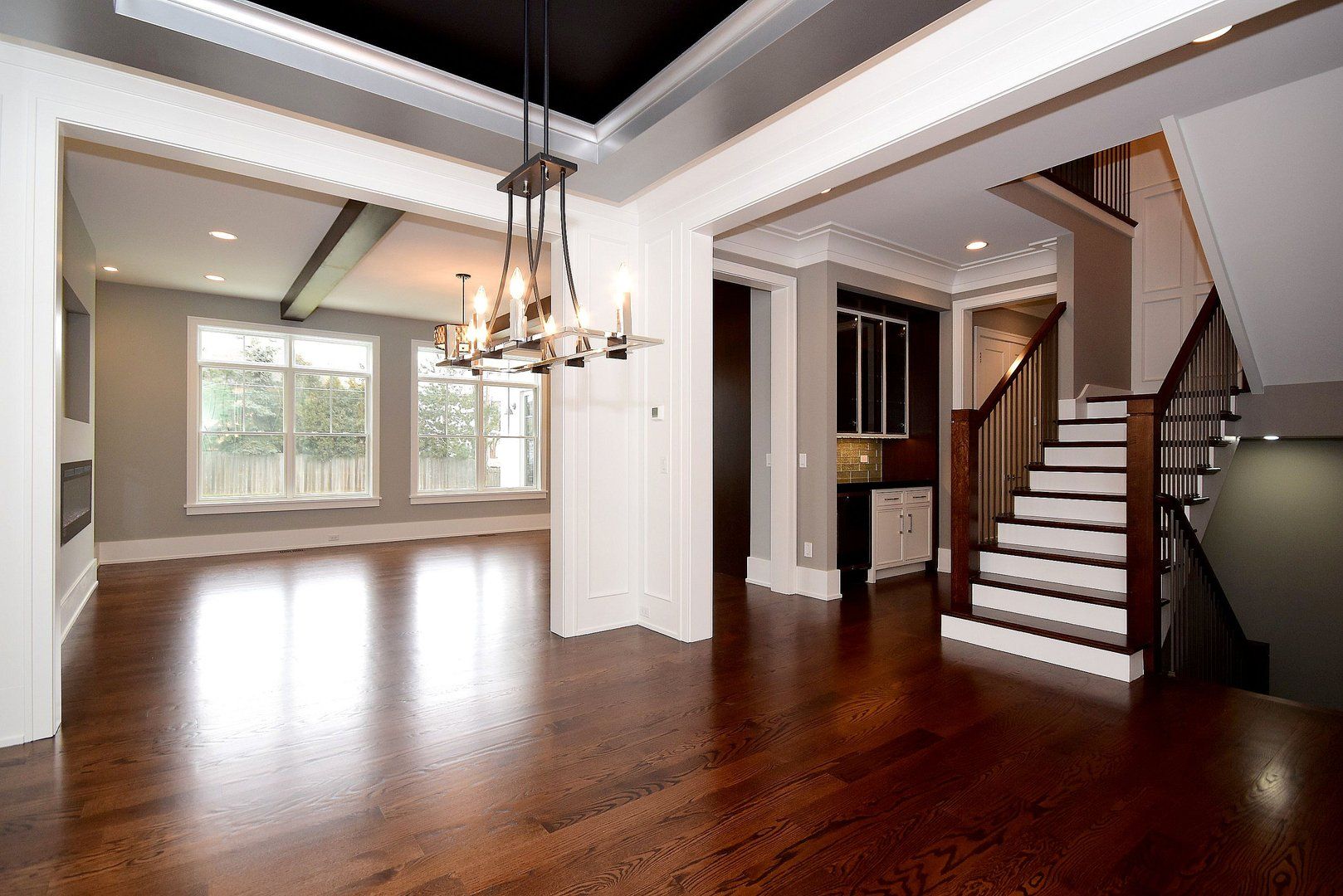 A large empty room with hardwood floors and stairs