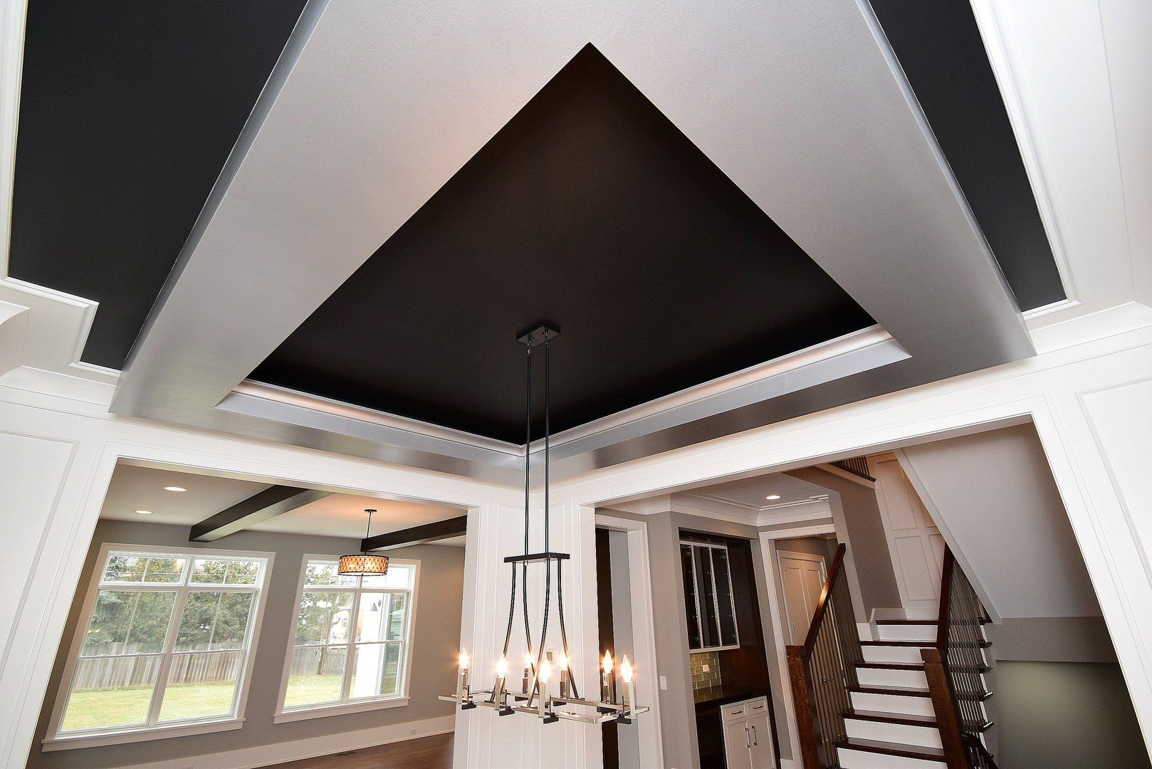 There is a chandelier hanging from the ceiling in the middle of the room.