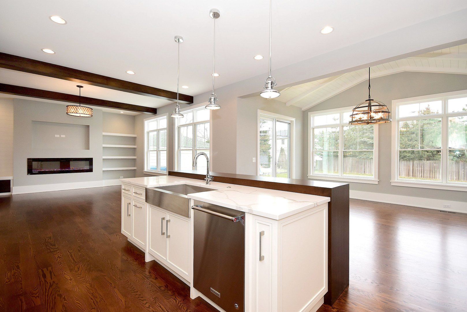 An empty kitchen with white cabinets and stainless steel appliances