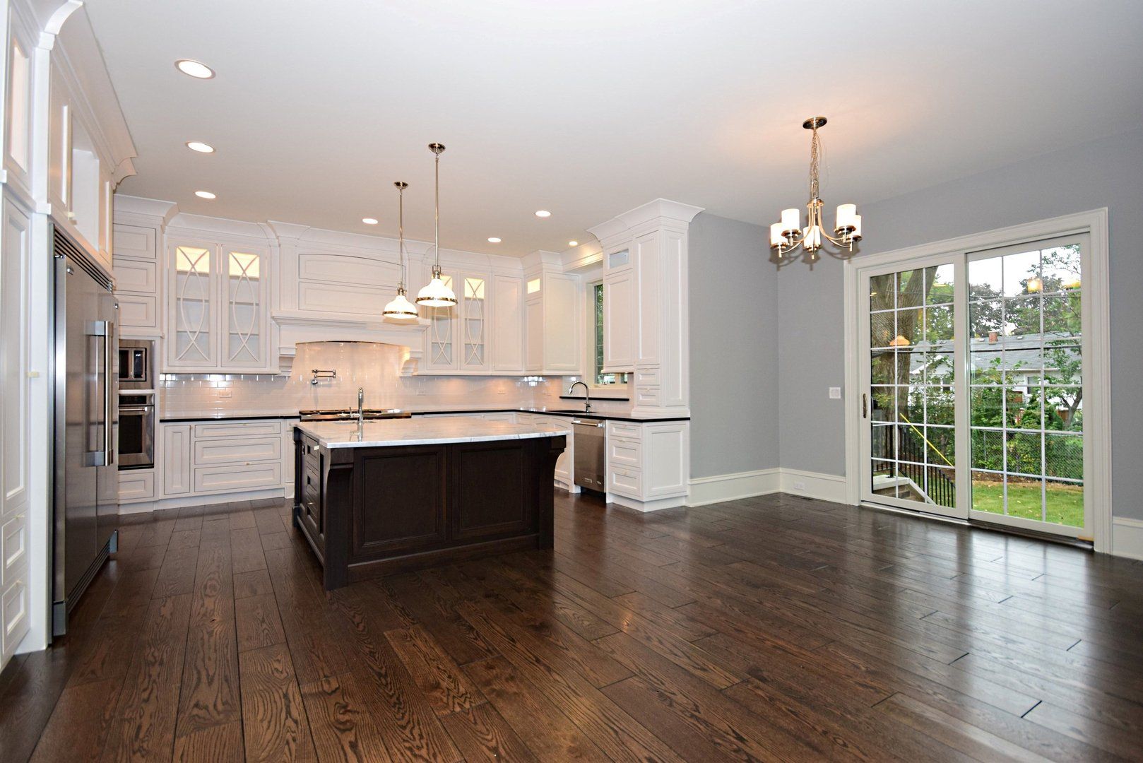An empty kitchen with a large island in the middle of the room.