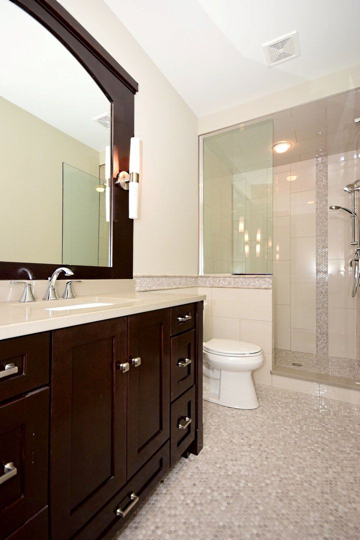 A bathroom with a toilet a sink and a mirror