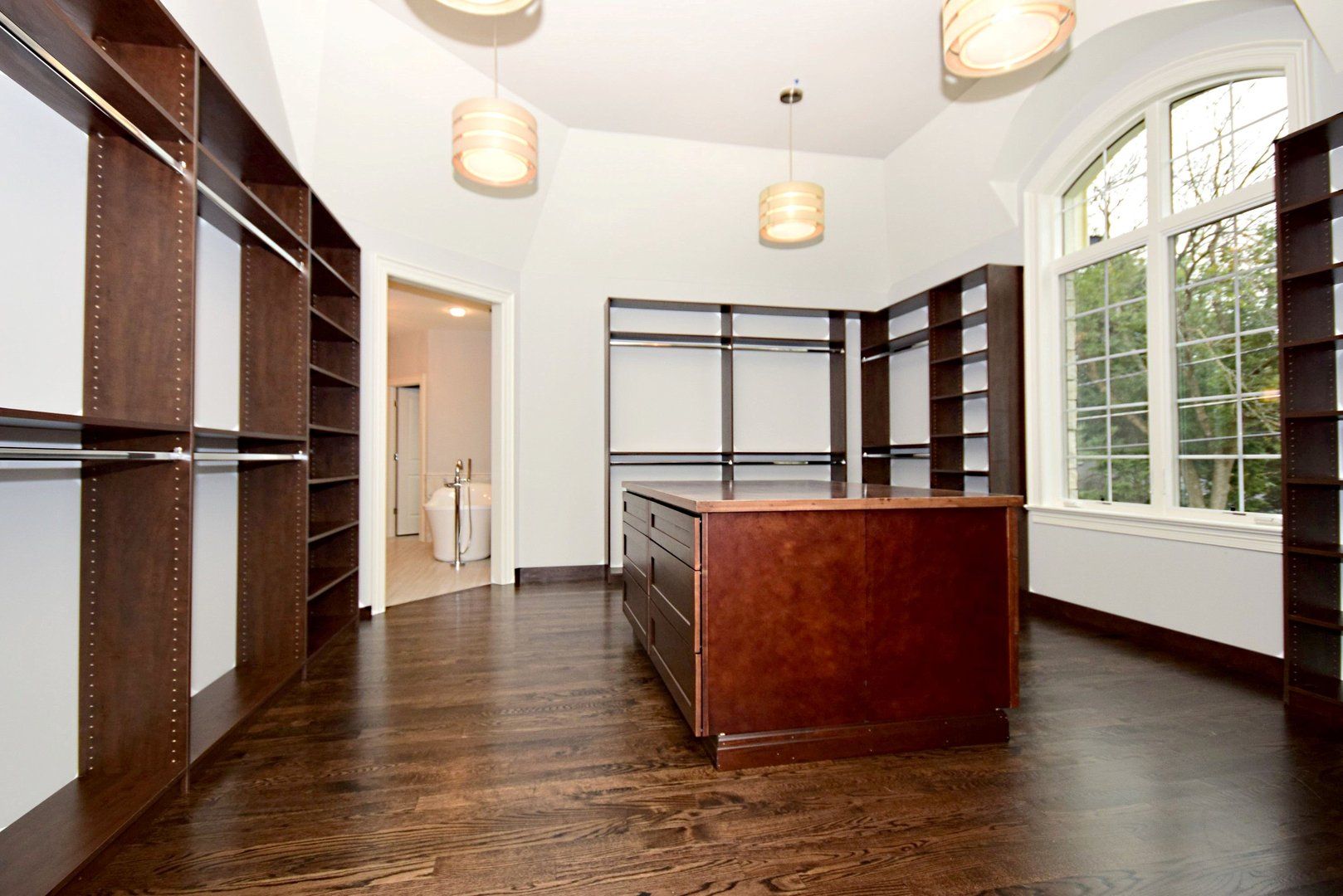 A walk in closet with a large island in the middle