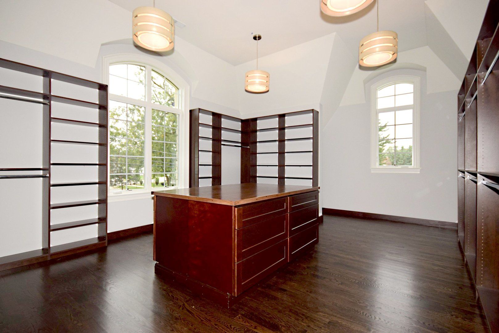 An empty walk in closet with a large island in the middle