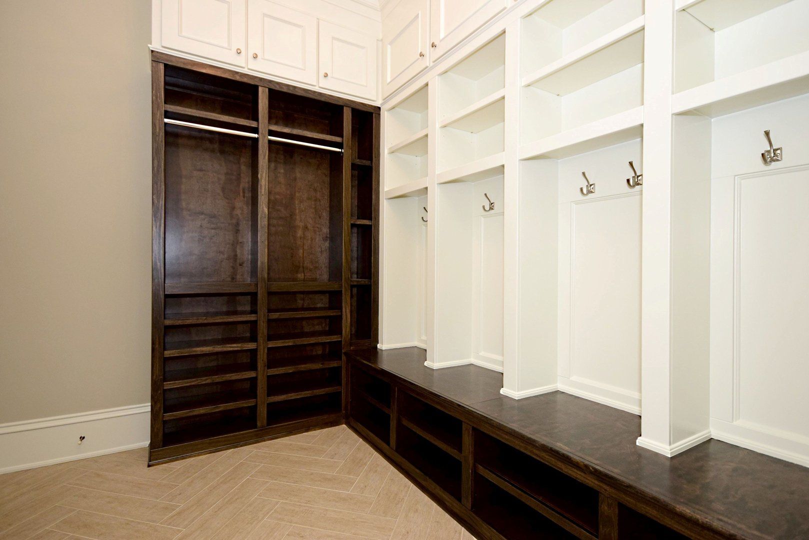 A walk in closet with lots of shelves and hooks.