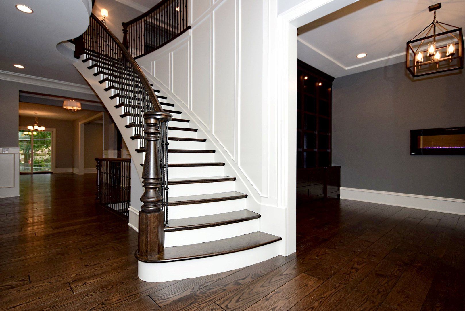 A large staircase with white steps and dark wooden railing