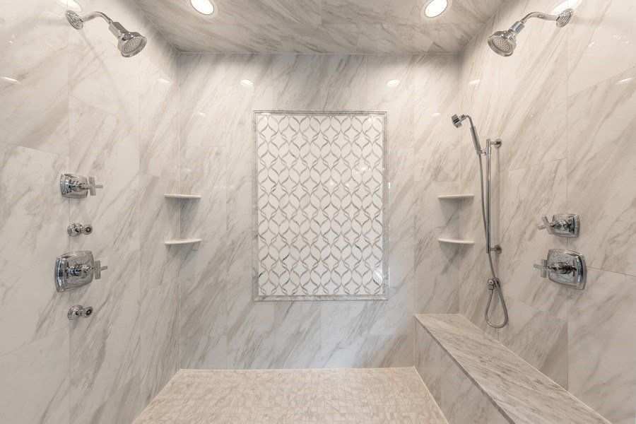 A bathroom with two showers and a bench.