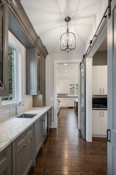 A kitchen with sliding barn doors and a sink