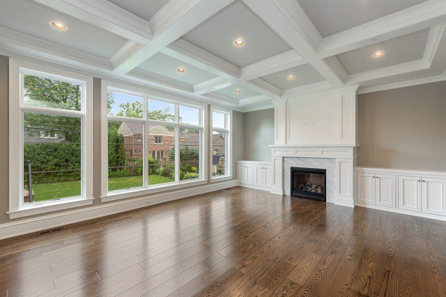 An empty living room with hardwood floors and a fireplace.